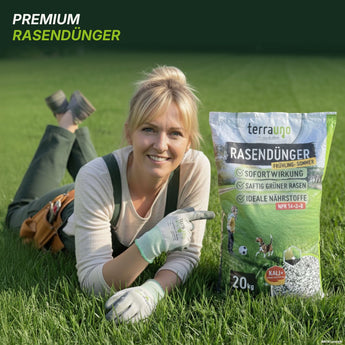 Eine lächelnde Frau in Gartenkleidung liegt auf grünem Rasen und zeigt auf einen 20-kg-Sack „TerraUno Frühlingsstarter-Set“. Auf dem Sack sind die Vorteile und Eigenschaften des Produkts in deutscher Sprache aufgeführt, was es zur idealen Wahl für eine effektive Rasenpflege und einen gesunden, kräftigen Rasen macht.