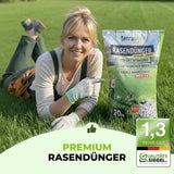 Eine lächelnde Frau kniet auf einer Wiese neben einem 20-kg-Sack TerraUno Saisonstart-Rasenset-Dünger mit hervorgehobenen Vorteilen und einem Verpackungstext, auf dem Saisonstart-Rasenset" und die Qualitätsstufe 1,3" angegeben sind.